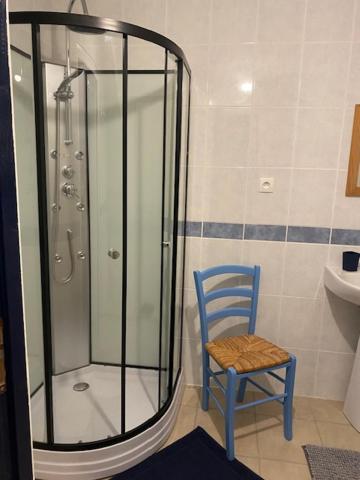 a shower and a blue chair in a bathroom at Le Moulin du Modon in Couffy
