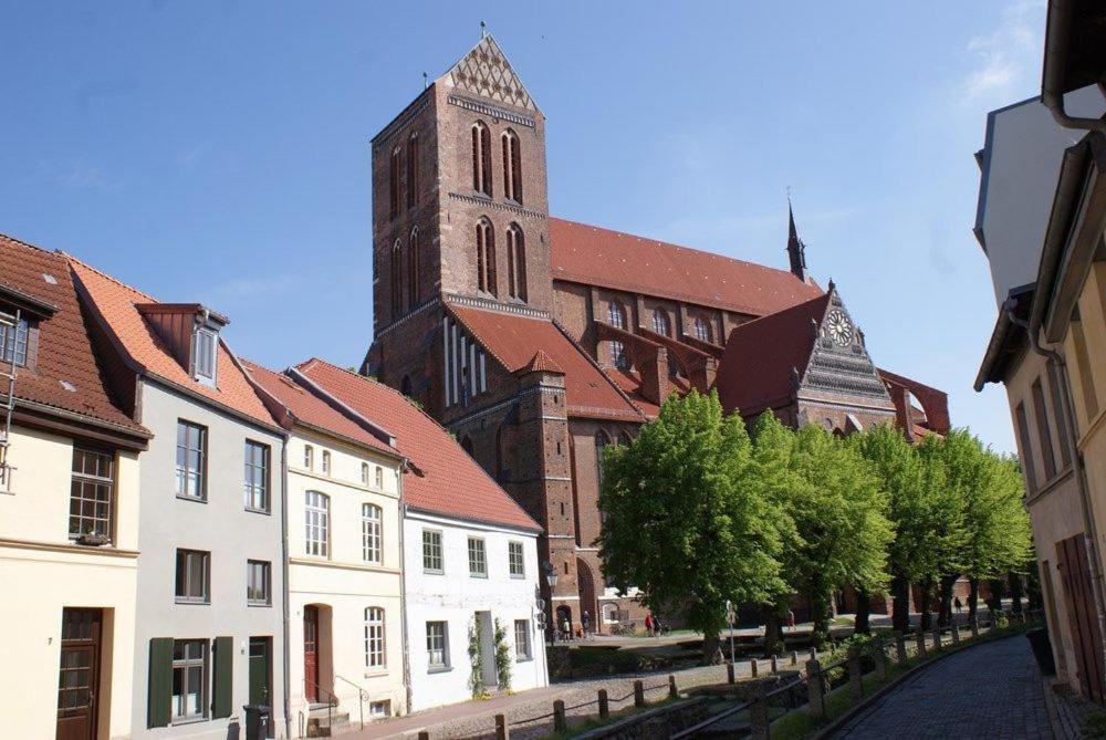 eine Gruppe von Gebäuden mit einem Turm und einer Kirche in der Unterkunft Stadtvilla Brügemann - ABC136 in Wismar