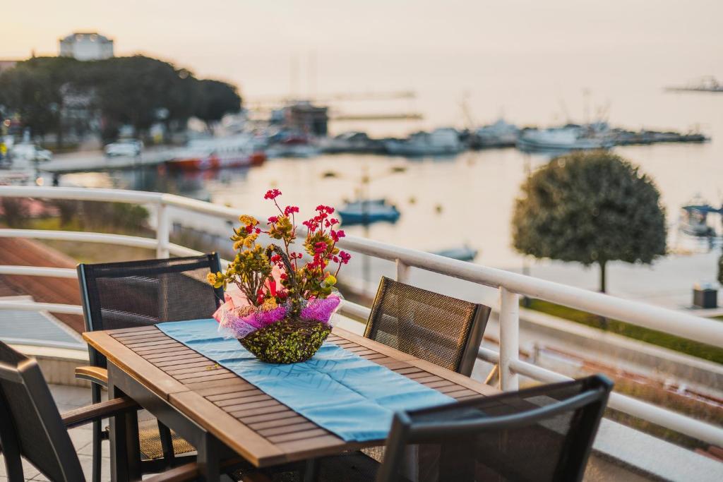 a table with a vase of flowers on a balcony at BLUEMARINE in Umag