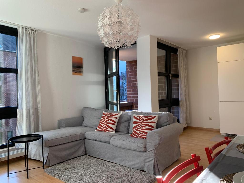 a living room with a couch and a chandelier at Comfort Apartment Düsseldorf Messe 2 rooms with kitchen, balcony, parking and elevator in Düsseldorf