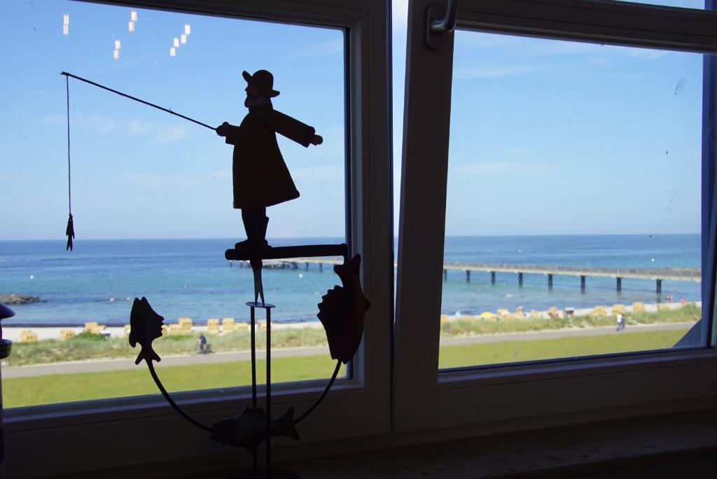 a window with a statue of a woman with a fishing rod at Pier 33 in Schönberger Strand