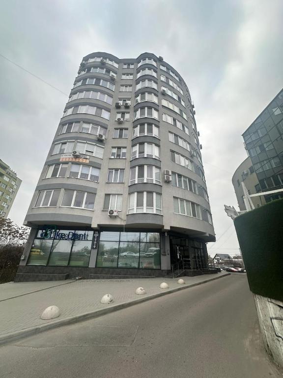 a tall white building with a street in front of it at Lux Apartmen Zona Circ in Chişinău