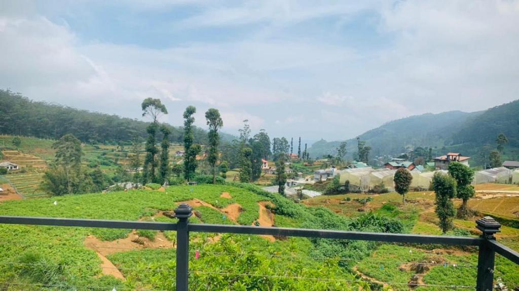 uma vista para um campo com montanhas ao fundo em Venus Inn Nuwara Eliya em Nuwara Eliya