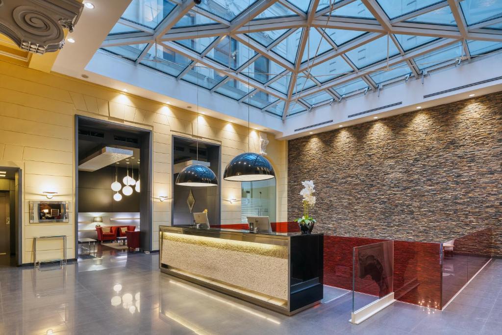 a lobby with a reception desk and a brick wall at Eurostars Palazzo Zichy in Budapest