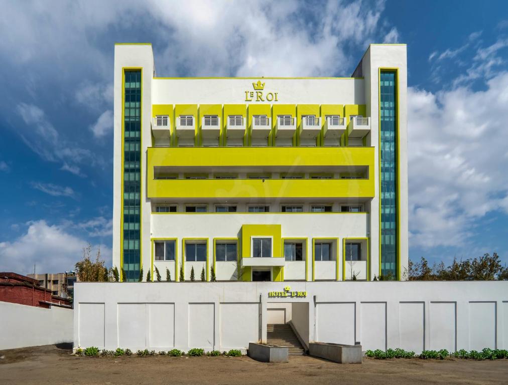a hotel with a yellow and white building at Le Roi Dehradun at Dehradun Railway Station in Dehradun