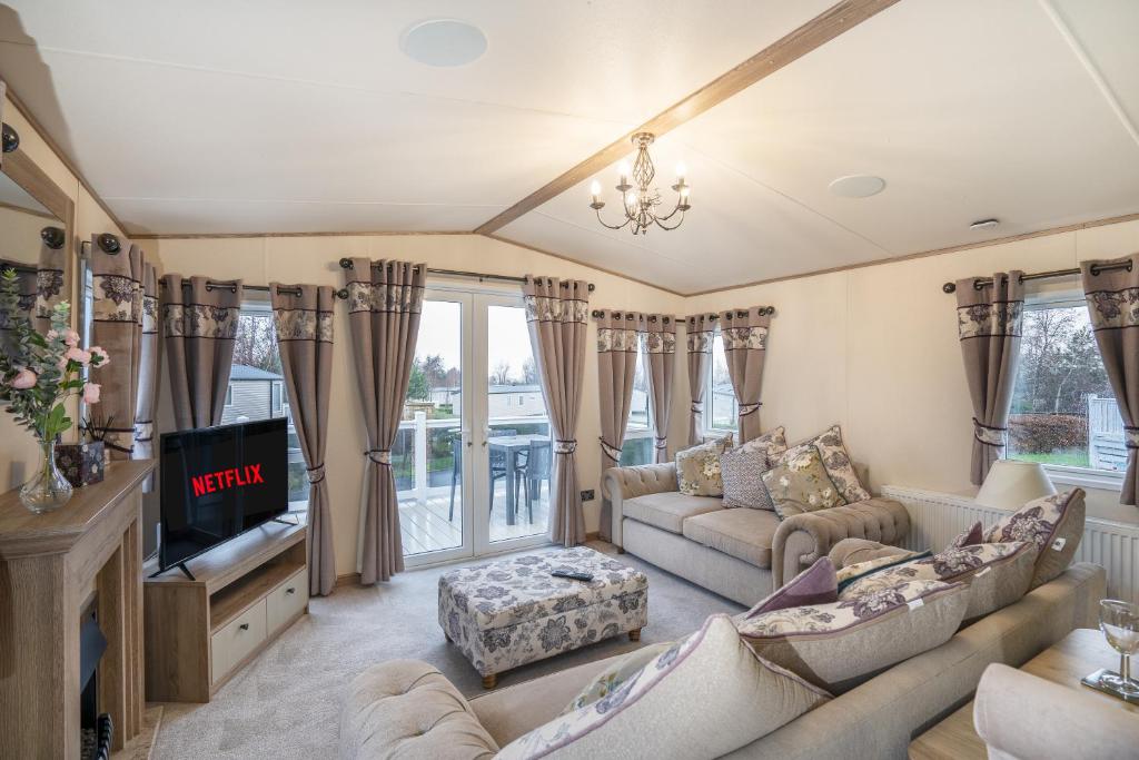 ein Wohnzimmer mit Sofas und einem TV in der Unterkunft QUEEN V - Luxury Caravan - 2Bed - Seton Sands in Port Seton
