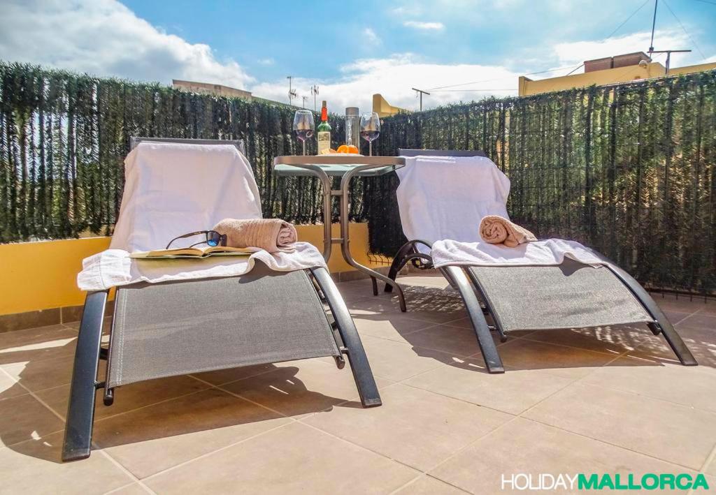 Dos sillas y una mesa en un patio. en Elegance Plaza Old Town, en Alcudia