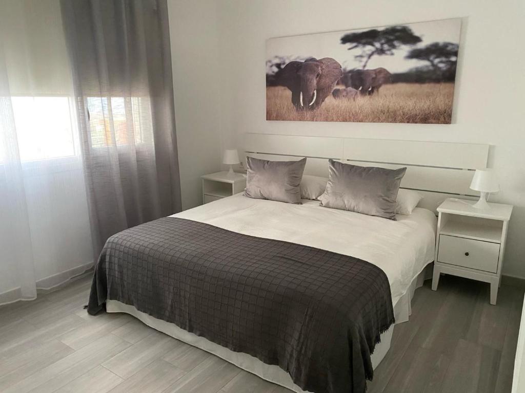 um quarto com uma cama e uma fotografia de elefantes em Casa Bagacera "Cera" em Ingenio