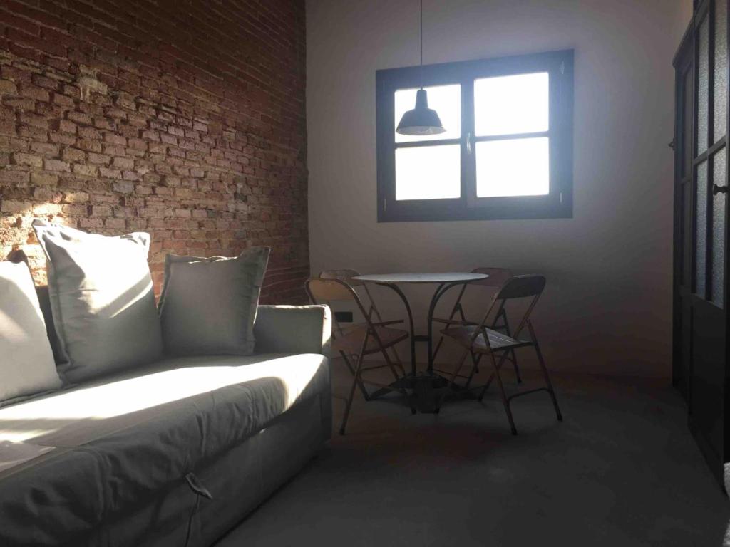 sala de estar con sofá, mesa y ventana en Cosy & Bright Apartment Near Ramblas en Barcelona