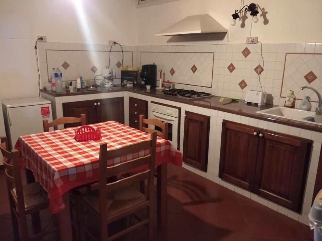 uma cozinha com uma mesa com uma toalha de mesa xadrez vermelha em B&B vacanze Mille Colori em Cinisi