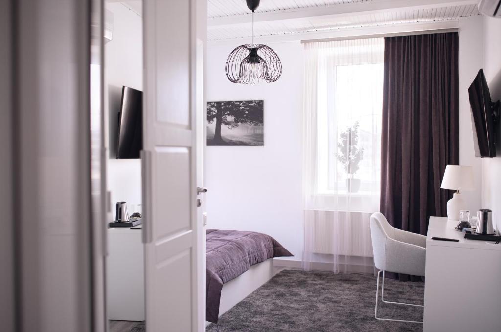 Schlafzimmer mit einem Bett und einem Fenster in der Unterkunft Laurentroom Hotel in Ukmergė