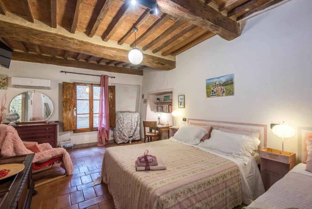 ブオンコンヴェントにあるLa Casa Gialla di Buonconventoのベッドルーム1室(ベッド2台、テーブル、椅子付)