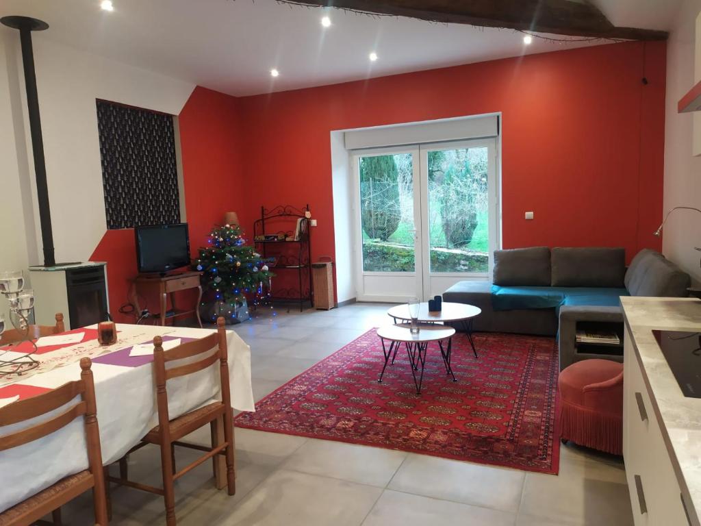 uma sala de estar com um sofá e uma mesa em La Grillère em Conliège