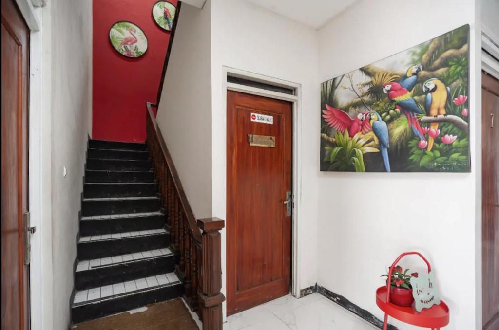 un couloir avec un escalier orné d'une peinture murale. dans l'établissement Mega Stay near Mall Kelapa Gading, à Jakarta