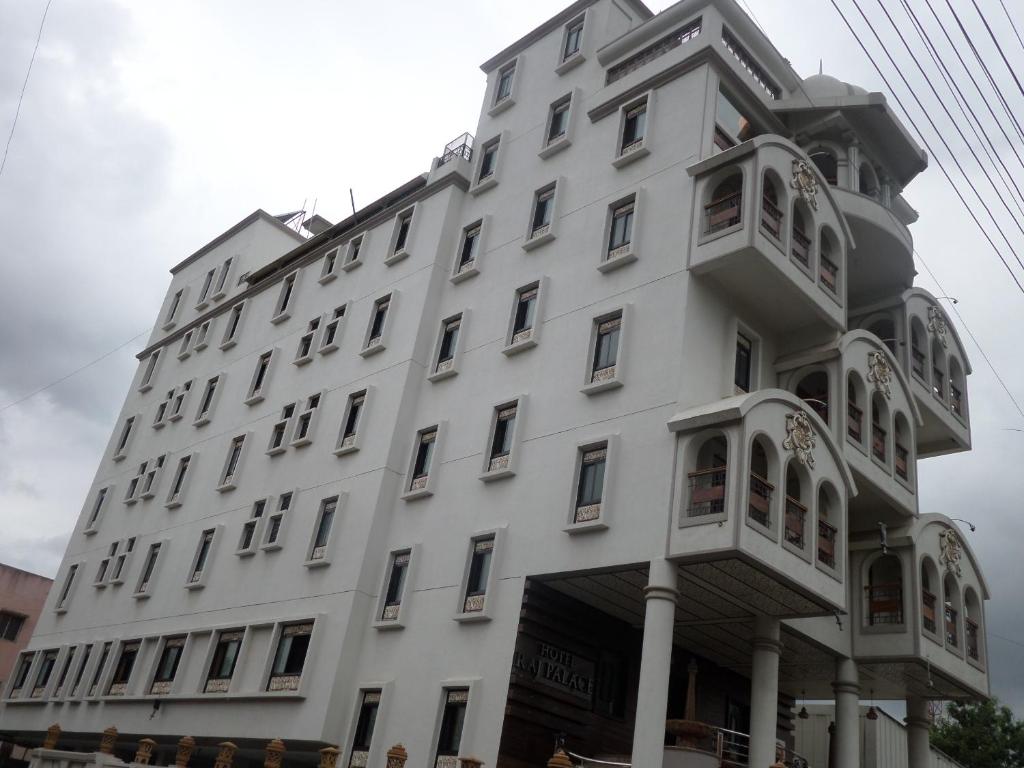 ein weißes Gebäude mit einem Balkon an der Seite in der Unterkunft Hotel Raj Palace in Ahmednagar