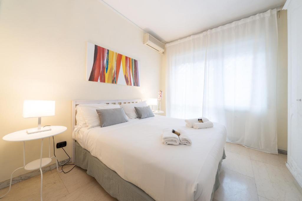 ローマにあるVATICAN Gregory Apartmentのベッドルーム1室(大きな白いベッド1台、タオル付)