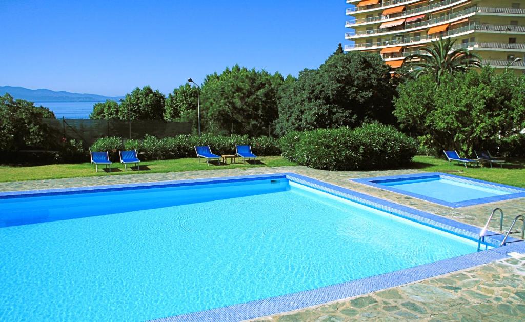 ein Pool mit zwei Stühlen und ein Gebäude in der Unterkunft Sun Beach in Ajaccio