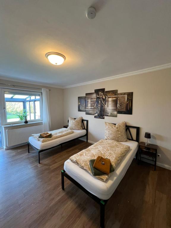 een slaapkamer met 2 bedden en een raam bij Ferienwohnung Aspelohe - Apartment 2 in Norderstedt