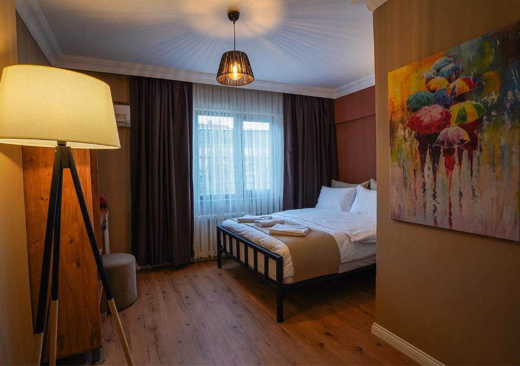 a bedroom with a bed with a painting on the wall at THE BEYBÛN HOTEL in Istanbul