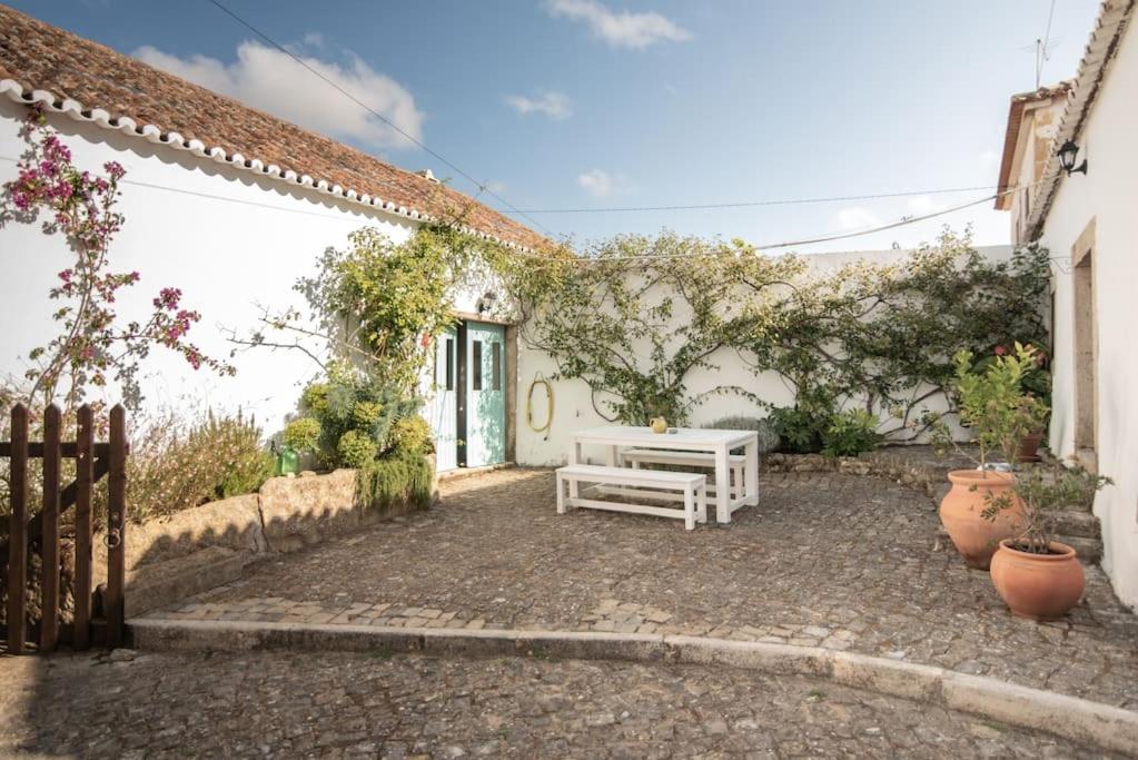 a patio with a white bench in front of a building at LIKE-HOME-Kina House-Casa do Lagar-Ericeira in Mafra
