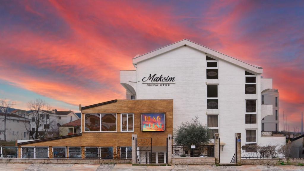 een gebouw met een bord aan de zijkant bij Hotel Maksim in Herceg-Novi