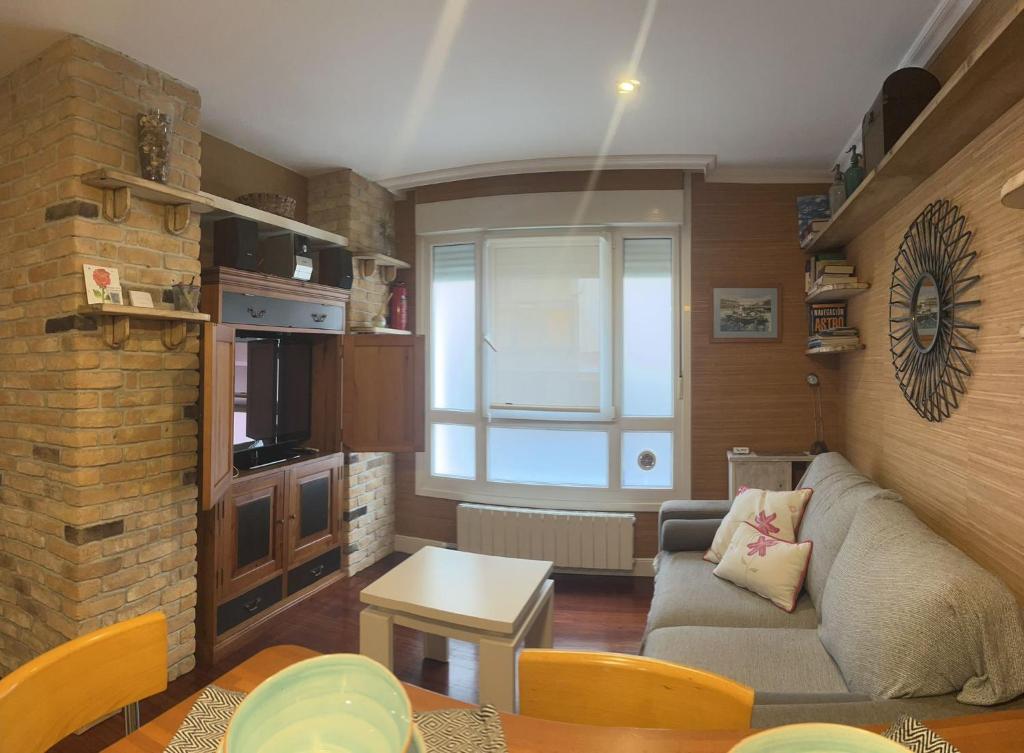 uma sala de estar com um sofá e uma parede de tijolos em Ideal Parejas em Lekeitio