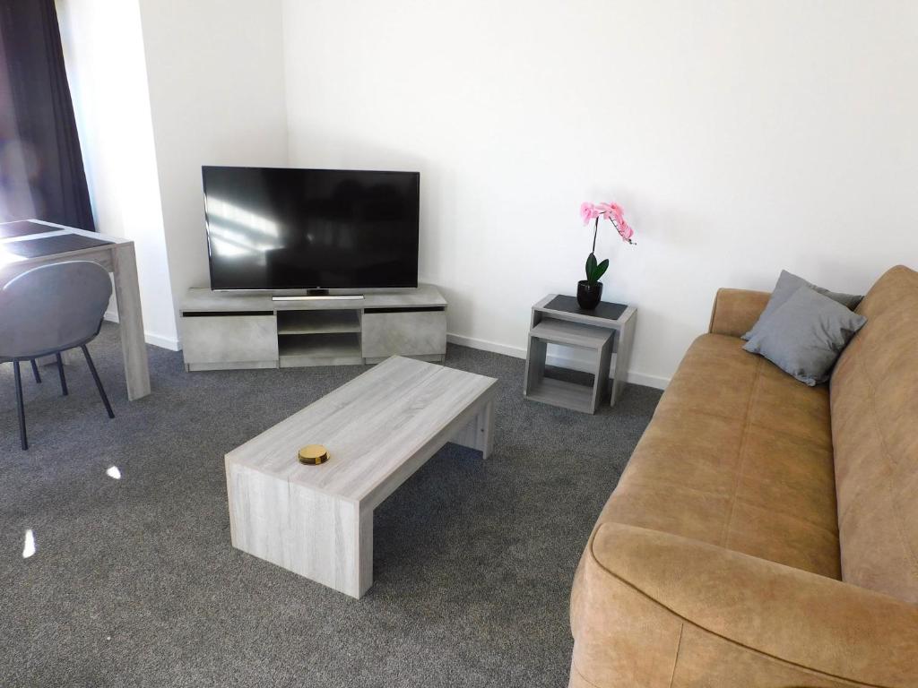 New & delightful 3 bed house in East Kilbride في غلاسكو: غرفة معيشة مع أريكة وتلفزيون بشاشة مسطحة