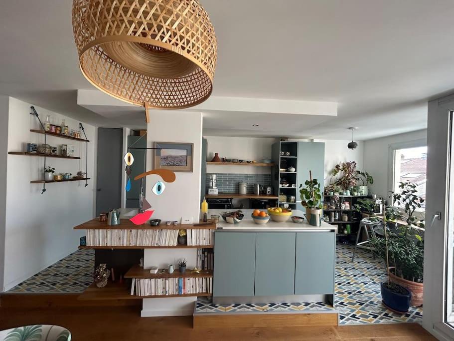 a kitchen with a island in the middle of a room at Appartement familial avec balcon et parking in Lyon