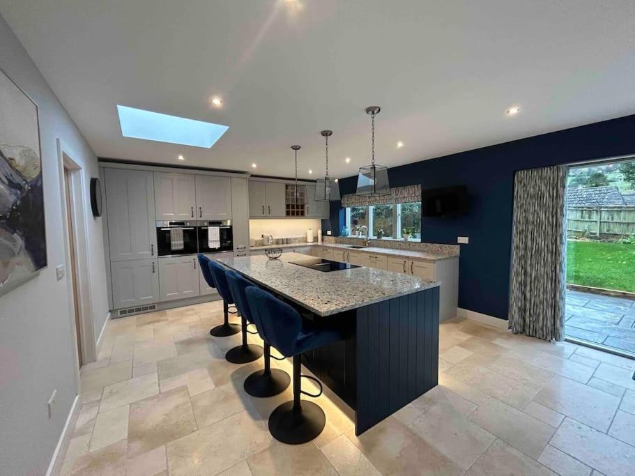 a kitchen with a large island with blue walls at Beautiful 4 bed semi rural house in Southam