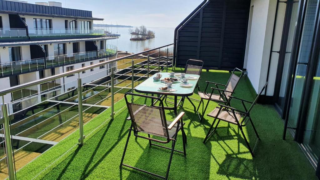 une table et des chaises sur le balcon d'un bâtiment dans l'établissement Kékvitorla Apartman Keszthely, à Keszthely