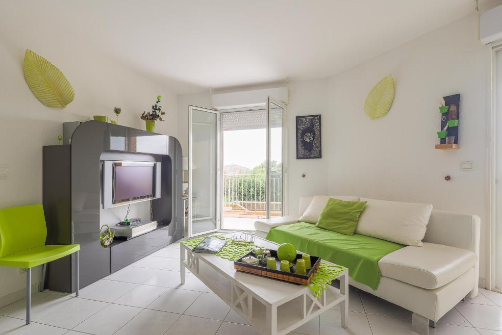 un soggiorno con un divano e una TV di Vue Marine - Appartement proche plage a LʼÎle-Rousse