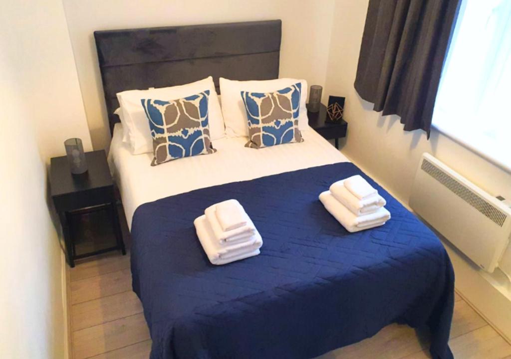 a bedroom with a bed with two towels on it at FW Haute Apartments at Wembley, Ground Floor 2 Bedroom and 1 Bathroom Flat, King or Twin beds and Double bed with FREE WIFI and PARKING in London