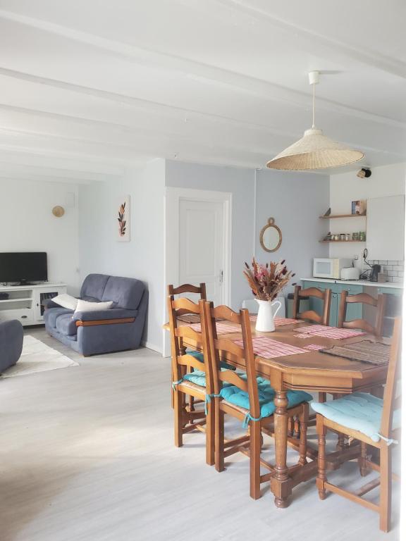 een eetkamer met een houten tafel en stoelen bij Maison au calme Plessala Le Mené in Saint-Udy