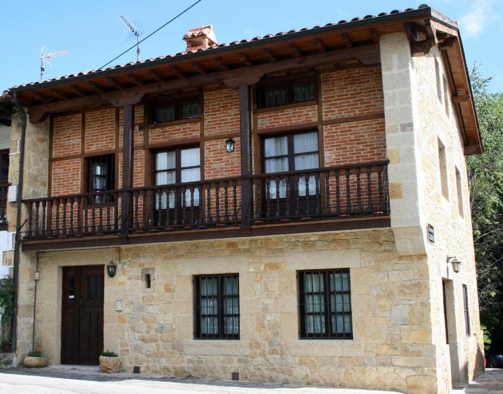 a house with a balcony on the side of it at Apartamentos Tarrio in Santillana del Mar