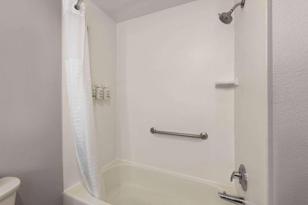 a bathroom with a shower with a tub and a toilet at La Quinta Inn and Suites by Wyndham at WaTiki Waterpark in Rapid City