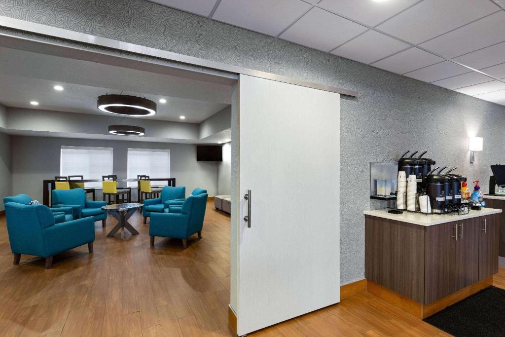 a waiting room with blue chairs and a table at La Quinta Inn and Suites by Wyndham at WaTiki Waterpark in Rapid City