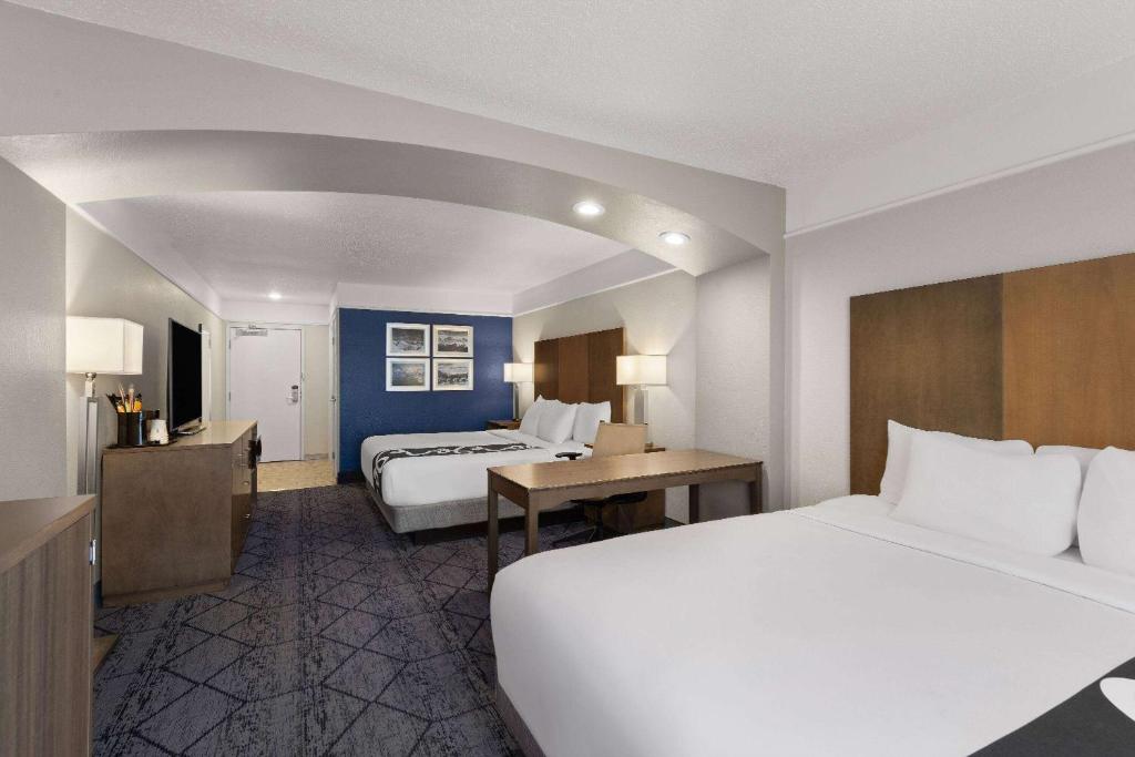 a hotel room with two beds and a desk at La Quinta Inn and Suites by Wyndham at WaTiki Waterpark in Rapid City