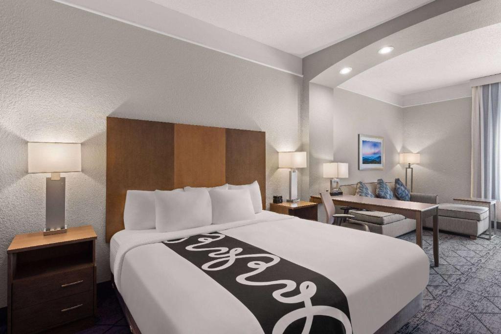 a hotel room with a large bed and a couch at La Quinta Inn and Suites by Wyndham at WaTiki Waterpark in Rapid City