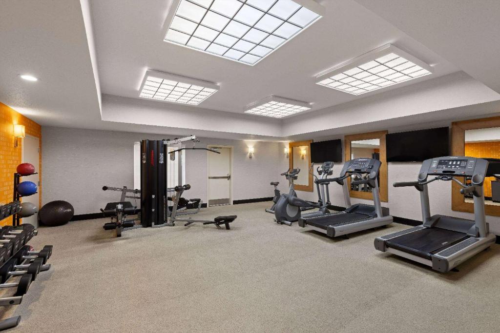 a gym with several treadmills and machines in a room at La Quinta Inn and Suites by Wyndham at WaTiki Waterpark in Rapid City