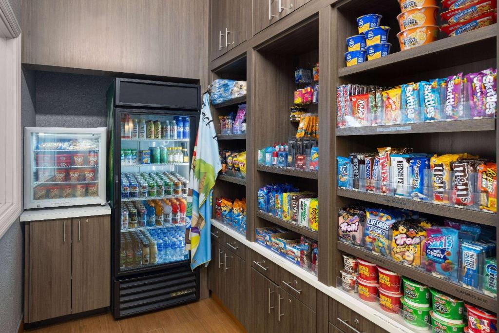 a store aisle with a refrigerator and lots of food at La Quinta Inn and Suites by Wyndham at WaTiki Waterpark in Rapid City