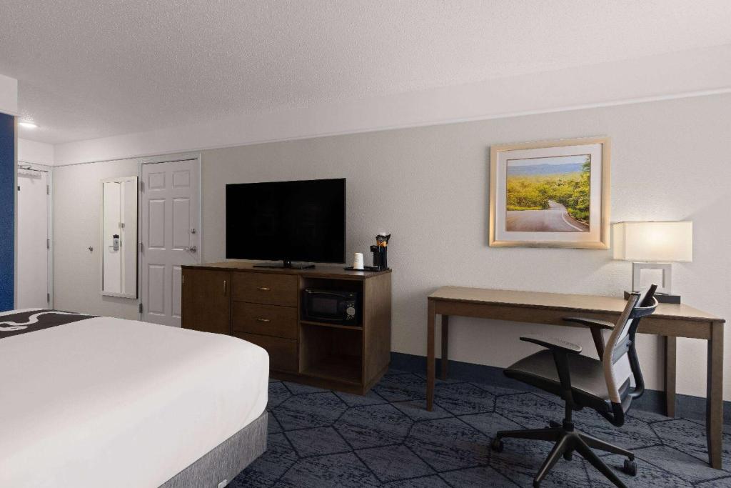 a hotel room with a bed and a desk with a television at La Quinta Inn and Suites by Wyndham at WaTiki Waterpark in Rapid City