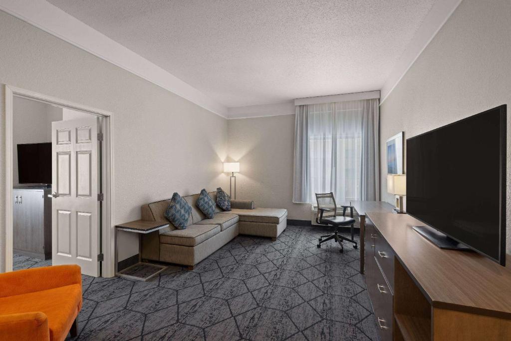 a living room with a couch and a flat screen tv at La Quinta Inn and Suites by Wyndham at WaTiki Waterpark in Rapid City