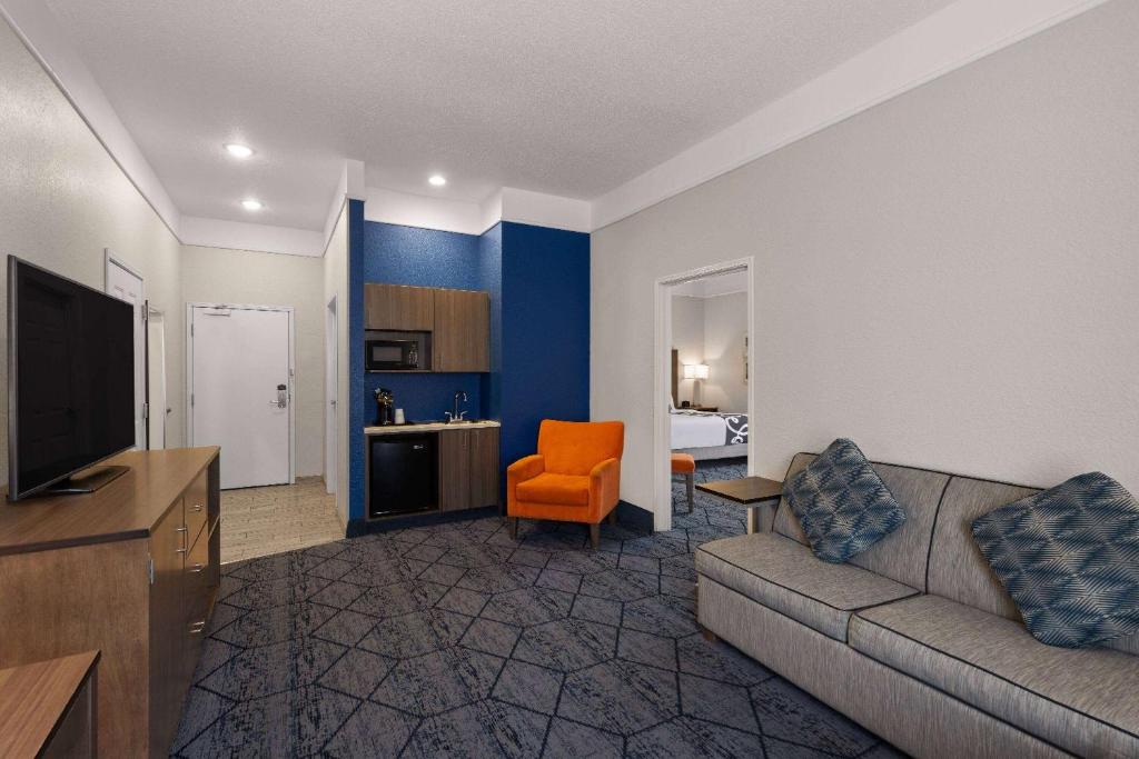 a living room with a couch and an orange chair at La Quinta Inn and Suites by Wyndham at WaTiki Waterpark in Rapid City