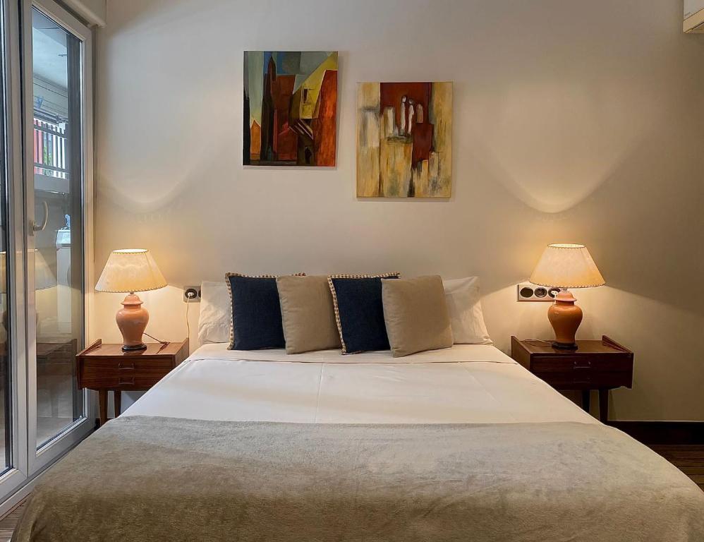 a bedroom with a large white bed with two lamps at KARRAKELLA apartamentua con aire in Orio