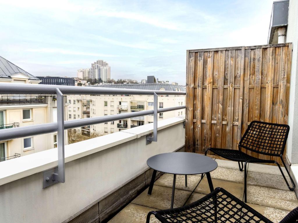 a balcony with two chairs and a table at ibis budget Issy Les Moulineaux Paris Ouest in Issy-les-Moulineaux