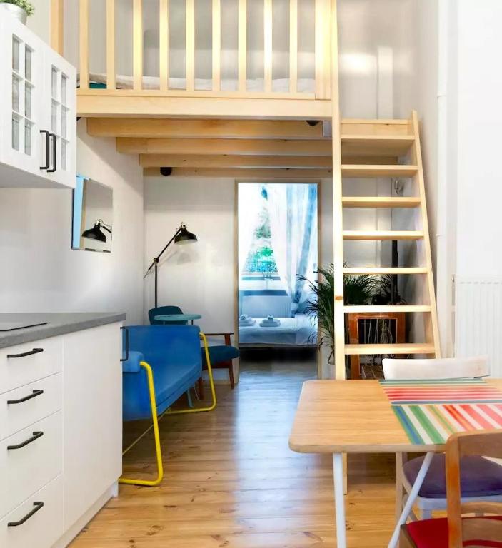 salon z łóżkiem na podwyższeniu i stołem w obiekcie WSTApartments RetroFunky w Warszawie