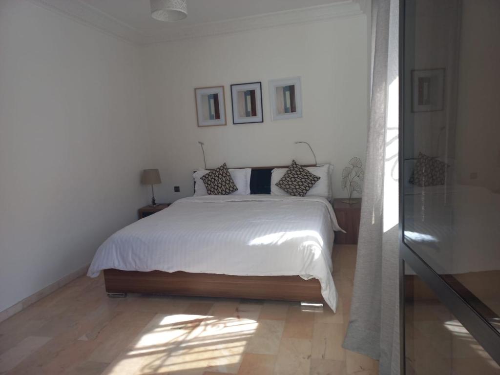 Belle Vue في مراكش: غرفة نوم بسرير ابيض عليها مخدات