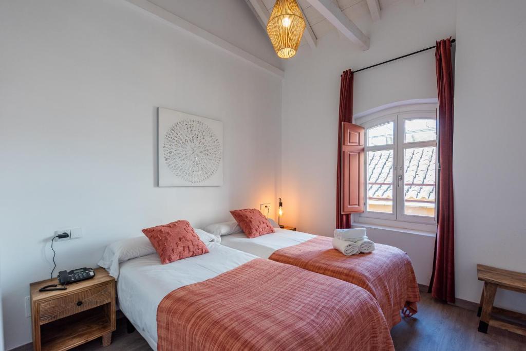 2 camas en una habitación con ventana en Málaga Boutique Adults Recommended, en Málaga