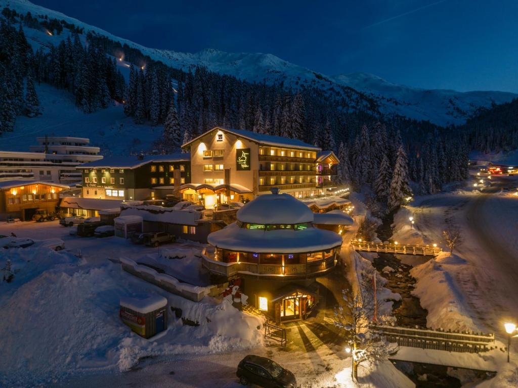 a large building in the snow at night at Berghotel Hochfügen in Hochfugen