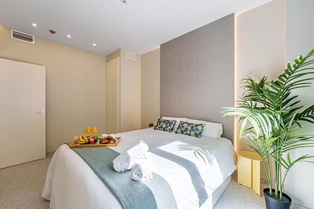 sypialnia z łóżkiem i tacą z owocami w obiekcie SUNSET MALAGA - PRIME & DESIGN w Maladze